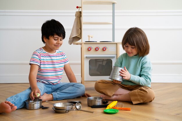 Full shot kinderen die samen op de vloer spelen