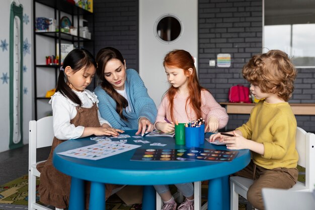 Full shot kinderen en leraar aan tafel