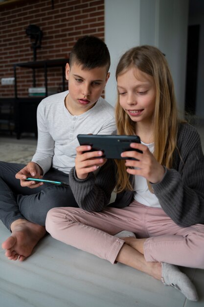 Full shot kinderen met smartphones binnenshuis