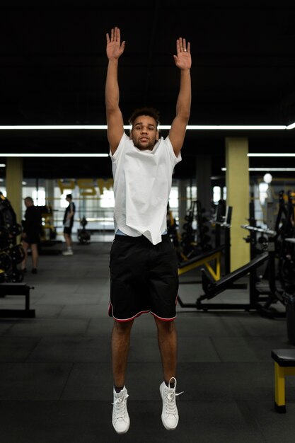 Full shot man doet burpee in de sportschool