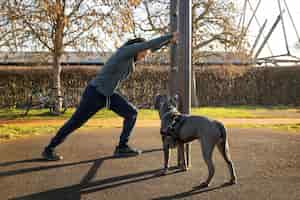 Gratis foto full shot man training met hond buiten