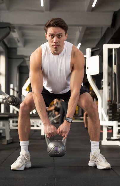 Gratis foto full shot man training met kettlebell