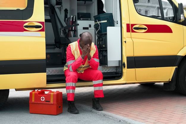 Full shot man zit in ambulance auto