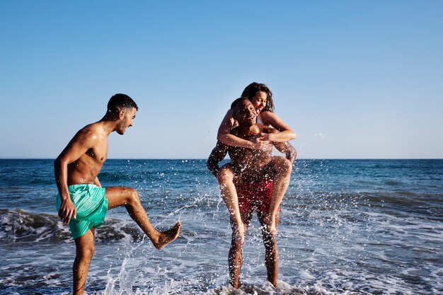 Full shot mensen die plezier hebben aan zee