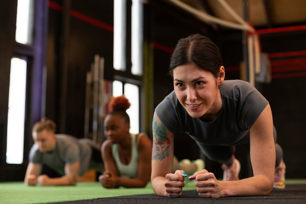 Gratis foto full shot mensen die samen trainen in de sportschool