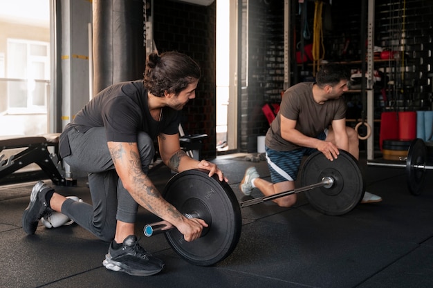 Gratis foto full shot mensen trainen in de sportschool