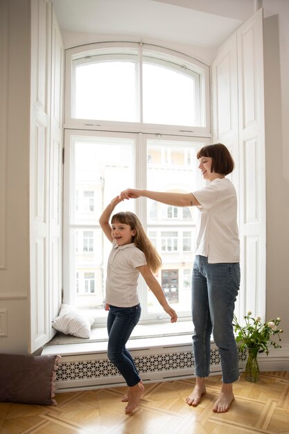 Full shot moeder danst met meisje