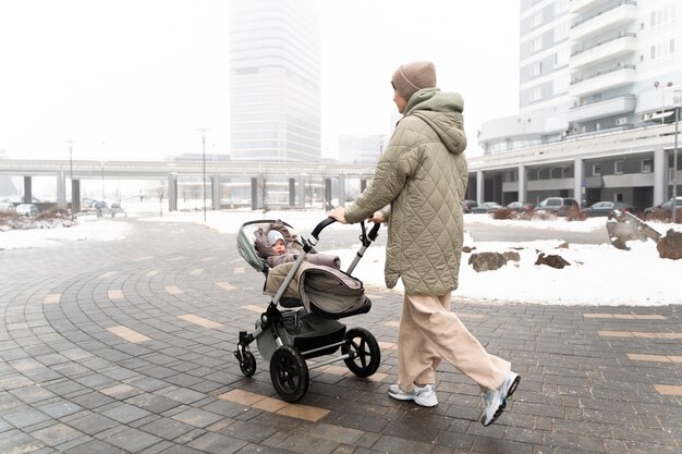 Full shot ouder met kinderwagen