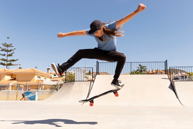 Gratis foto full shot skateboarder die trucs doet