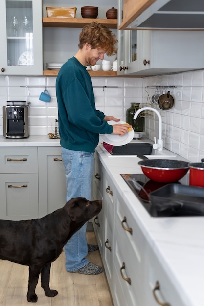 Full shot smiley man afwas in de keuken