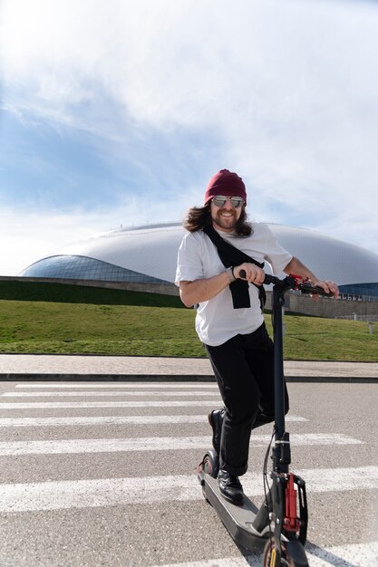 Full shot smiley man op elektrische scooter