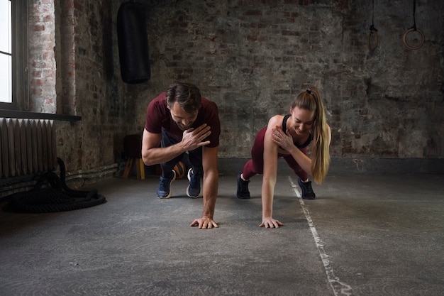 Full shot smiley mensen die samen burpees doen