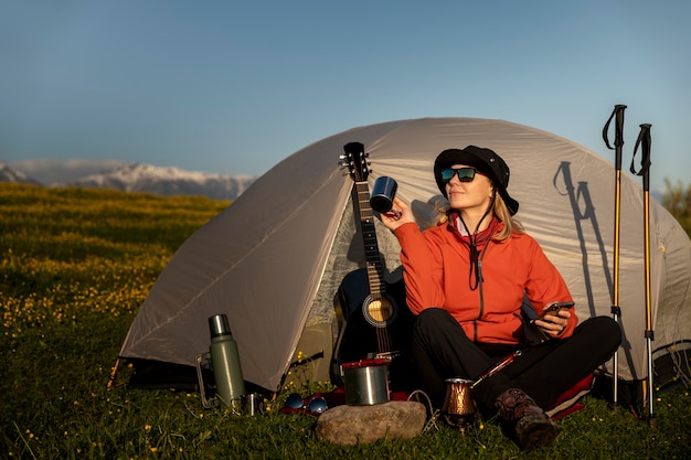 Full shot smiley vrouw kamperen met tent