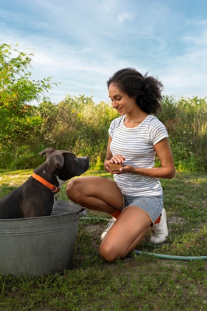 Gratis foto full shot smiley vrouw wassen hond