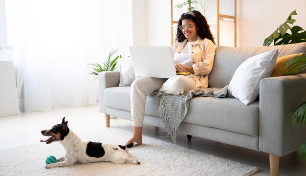 Full shot smiley vrouw zittend op de bank