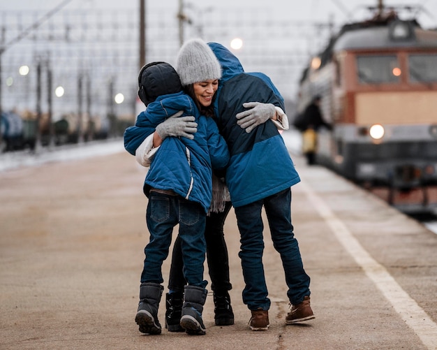 Full shot vrouw knuffelen kinderen buiten