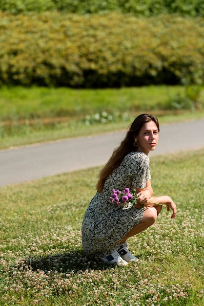 Gratis foto full shot vrouw poseren met bloemen