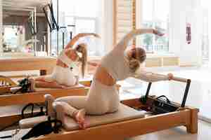 Gratis foto full shot vrouwen die samen pilates doen