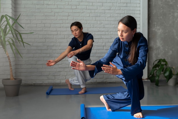 Full shot vrouwen die samen tai chi beoefenen