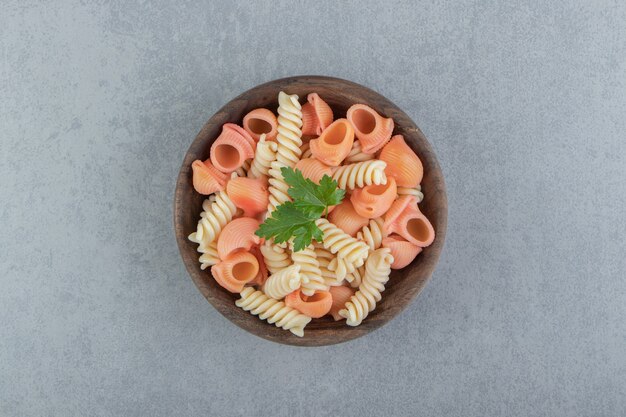 Fusilli en zeeschelppasta in houten kom