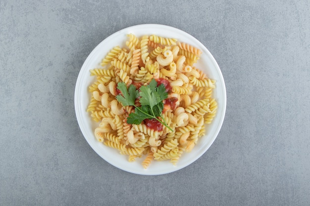 Fusilli pasta met saus op witte plaat.