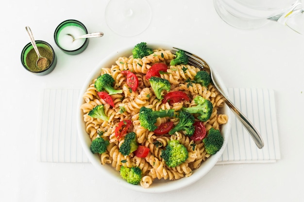 Fusilli pastasalade met tomaat en broccoli op servet