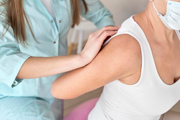 Fysiotherapeut die therapie ondergaat met een vrouwelijke patiënt