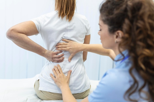Fysiotherapeut doet helende behandeling op de rug van de vrouw rugpijn patiënt behandeling arts massagetherapeut kantoor syndroom