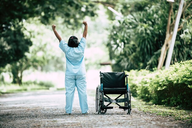 Fysiotherapie hogere vrouw met rolstoel in het park