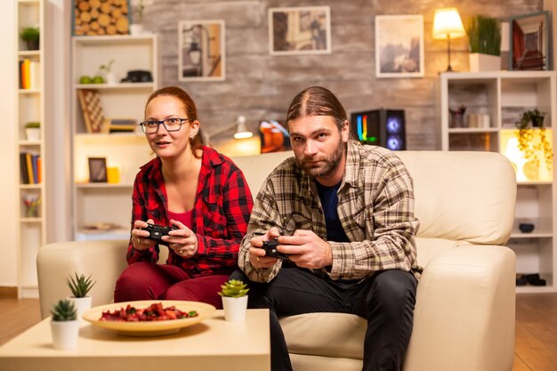 Gamers koppelen het spelen van videogames op de tv met draadloze controllers in handen.