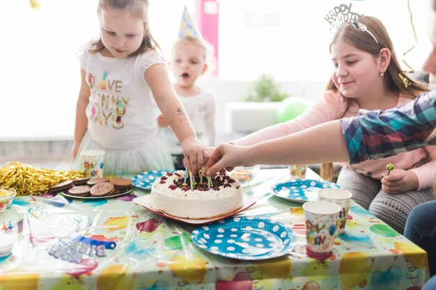 Gasten die kaarsen uit de taart halen