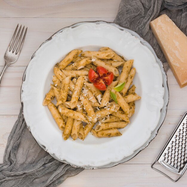 Gastronomische smakelijke Italiaanse pennedeegwaren met tomaat en kruiden op een witte plaat