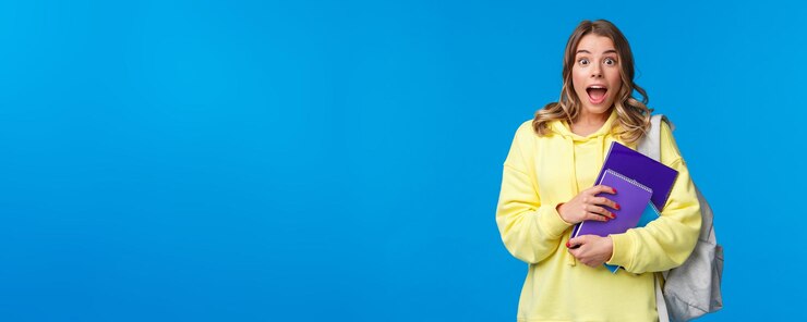 Gratis Foto geamuseerd en blij opgewonden mooi blond meisje in gele hoodie hijgend en verbaasd kijkend als geweldig hoor
