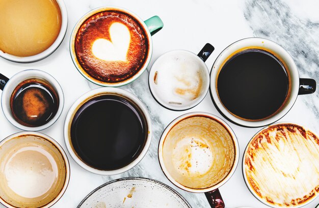 Geassorteerde koffiekoppen op een marmeren achtergrond