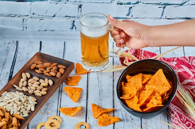 Geassorteerde snacks, chips en bier op blauwe tafel. tafel voor een groep vrienden.