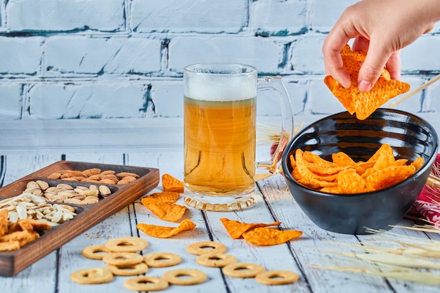 Geassorteerde snacks, chips en bier op blauwe tafel. Tafel voor een groep vrienden.