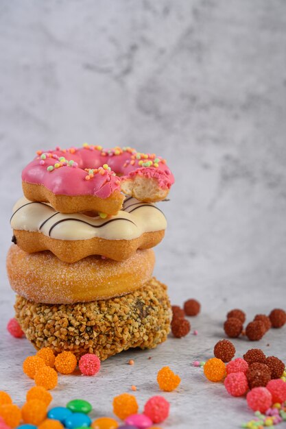 Geassorteerde stapel donuts en aardbei gebeten donuts bovenop geplaatst.