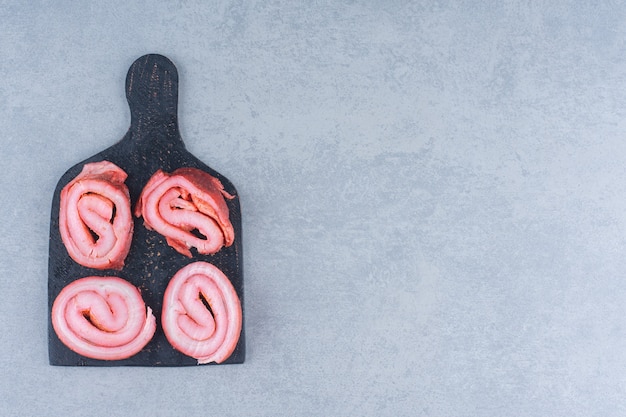 Gebakken bacons op zwarte snijplank.