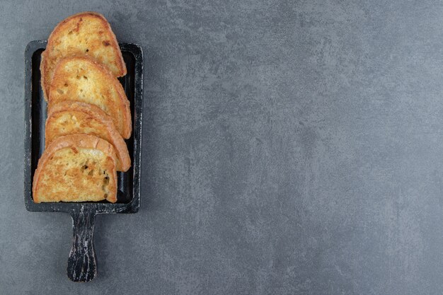 Gebakken brood met ei op zwart bord.