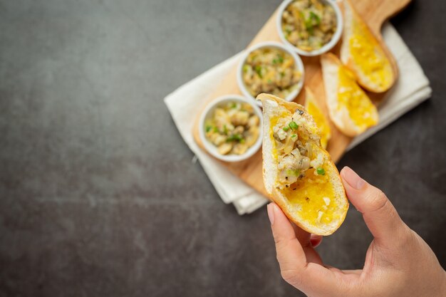 Gebakken clam met knoflook en boter geserveerd met lookbrood op donkere achtergrond