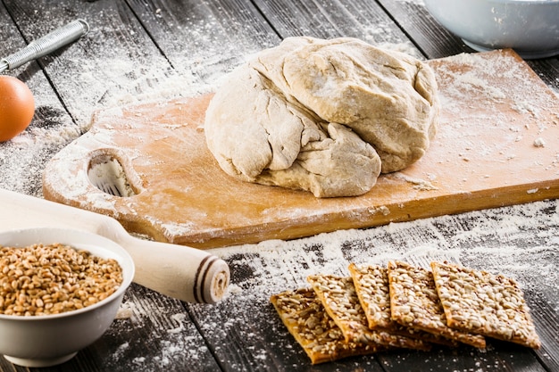 Gebakken deeg op hakbord en gezonde koekjes met zonnebloempitten en lijnzaad