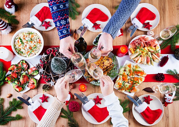 Gebakken kalkoen. Kerstdiner. De kersttafel wordt geserveerd met een kalkoen, versierd met helder klatergoud en kaarsen. Gebakken kip, tafel. Familie diner. Bovenaanzicht, handen in het frame