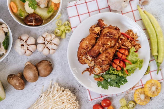 Gebakken kippenbout met tomaat, chili, gebakken ui, sla, maïs en naaldchampignon.