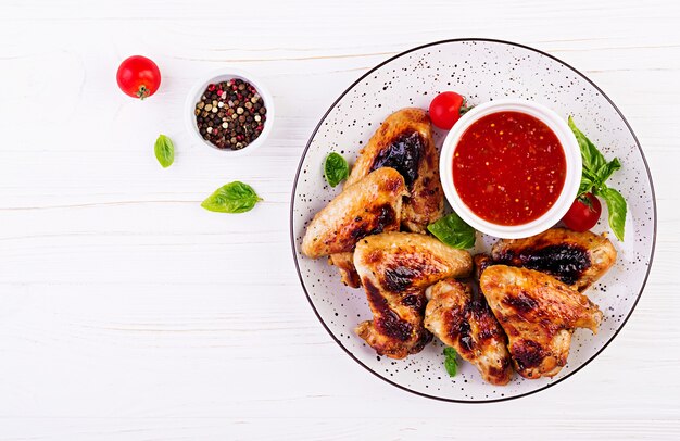 Gebakken kippenvleugels in de Aziatische stijl en tomatensaus op plaat