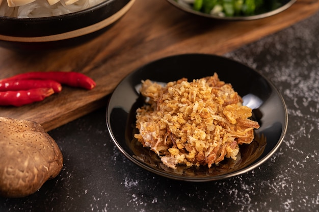 Gebakken knoflook op zwarte plaat met chili en shiitake.