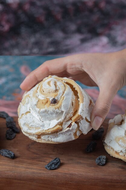 Gebakken meringuekoekje met zwarte rozijnen en witte chocolade erop.