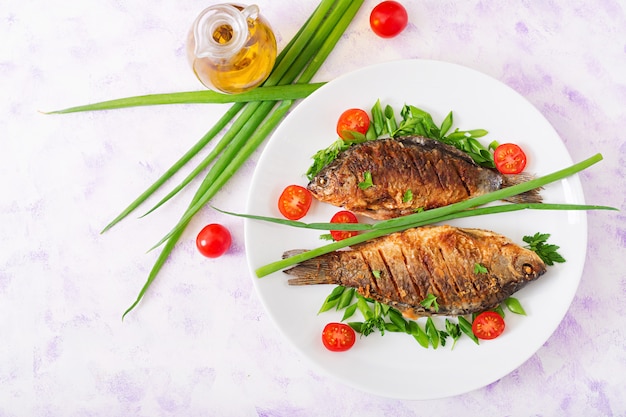 Gebakken viskarper en verse groentesalade. Plat liggen. Bovenaanzicht