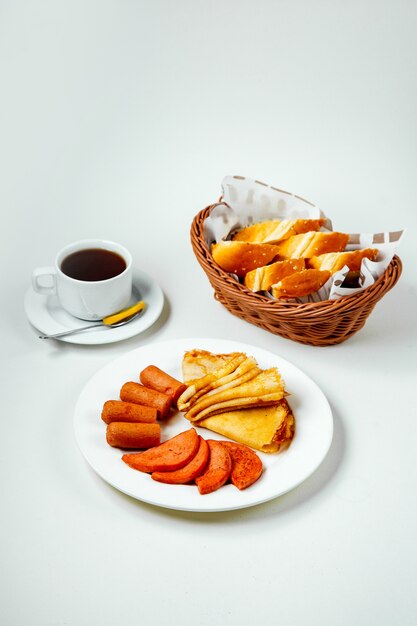 Gebakken worst worst en pannenkoek plaat zwarte thee en ontbijt voor het ontbijt