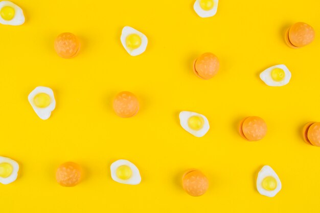 Gebraden ei gummies en hamburgersuikergoed op gele achtergrond