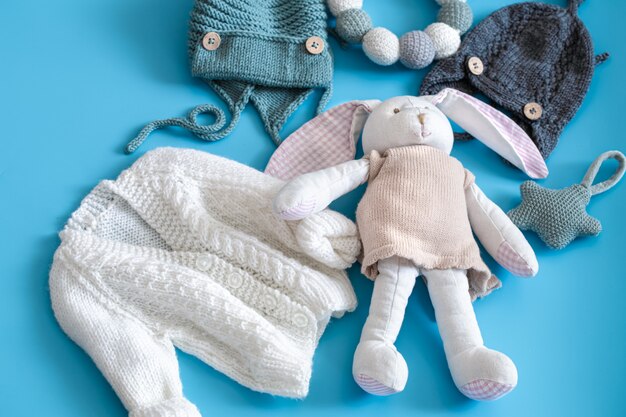 Gebreide babykleertjes en accessoires op blauw